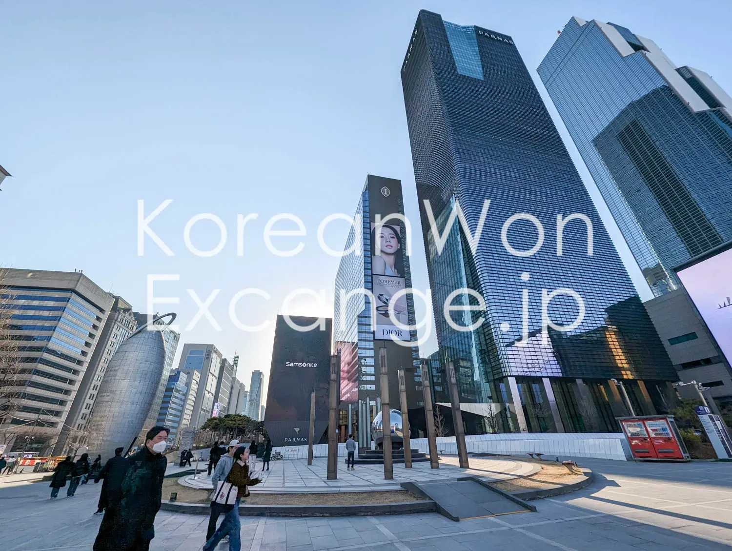 Gangnam business district in Seoul, with high-rises lining a street busy with people and cars.